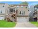 Back exterior featuring a two-car garage, screened porch, and wooden stairs at 619 R L Stowe Rd, Belmont, NC 28012