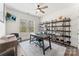 Bright home office featuring a large window, ceiling fan, stylish desk, and modern shelving unit at 619 R L Stowe Rd, Belmont, NC 28012