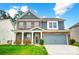 Two-story home featuring a brick and gray siding exterior, a two-car garage, and a well-manicured lawn at 670 Belle Grove Dr, Clover, SC 29710
