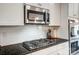 Close up on the cooktop in the kitchen, microwave, and granite countertop at 670 Belle Grove Dr, Clover, SC 29710