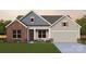 Charming one-story home with a brick accent, covered porch, and a two-car garage at 7153 Chamberlain Dr, Harrisburg, NC 28075