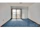 Cozy bedroom featuring a sliding glass door with lake views and light filtering through vertical blinds at 7831 Spinnaker Bay Dr # 106, Sherrills Ford, NC 28673