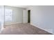 Neutral bedroom featuring window, plush carpet, and closet at 8545 Filbert Ln, Charlotte, NC 28215