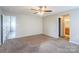 Spacious bedroom featuring a ceiling fan and carpeted floors with an open doorway at 8545 Filbert Ln, Charlotte, NC 28215