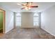 Spacious bedroom featuring a ceiling fan and carpeted floors and two large windows at 8545 Filbert Ln, Charlotte, NC 28215