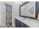 Well-lit bathroom with a gray vanity, modern fixtures, and a shower with a patterned curtain at 9004 Cebu Ct, Fort Mill, SC 29708