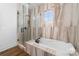 Elegant bathroom featuring a soaking tub, walk-in shower, and marble-look tile surround at 101 N Cove Key Ln, Mooresville, NC 28117