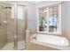 Bright bathroom with a soaking tub, shower, and natural light, offering a relaxing retreat at 101 N Cove Key Ln, Mooresville, NC 28117