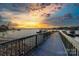 Scenic view of a wooden dock leading out to a calm lake under a colorful sunset sky at 101 N Cove Key Ln, Mooresville, NC 28117