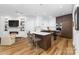 Stylish kitchen features a marble island, modern lighting, stainless steel appliances, and seamless living room integration at 101 N Cove Key Ln, Mooresville, NC 28117