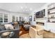 Inviting living room with a cozy fireplace, media shelving, comfortable seating, and a seamless transition to the outdoors at 101 N Cove Key Ln, Mooresville, NC 28117