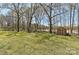 Landscaped backyard featuring a fire pit, storage shed, and mature trees, offering a peaceful and private outdoor space at 10209 New Town Rd, Marvin, NC 28173