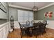 Elegant dining room featuring hardwood floors, wainscoting, a modern chandelier, and large window at 10209 New Town Rd, Marvin, NC 28173