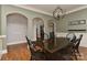Stylish dining room with hardwood floors, neutral walls, modern lighting, and adjacent arched entryways at 10209 New Town Rd, Marvin, NC 28173