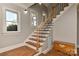 Elegant staircase with wooden steps, decorative iron railings, and natural light at 10209 New Town Rd, Marvin, NC 28173