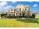Beautiful two-story home with manicured lawn, stone accents, and welcoming front porch with tasteful landscaping at 1022 Torrens Dr, Monroe, NC 28110