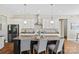 Bright kitchen features granite countertops, stainless steel appliances, kitchen island with seating, and decorative lighting at 1022 Torrens Dr, Monroe, NC 28110