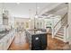 Open kitchen with island, coffered ceilings, stainless appliances, and hardwood floors, adjacent to a living area at 1022 Torrens Dr, Monroe, NC 28110