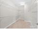 Spacious walk-in closet with metal shelving units, and carpeted floor at 1022 Torrens Dr, Monroe, NC 28110