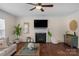 Bright living room with a fireplace, a ceiling fan, stylish decor, and hardwood flooring at 10415 Waxhaw Manor Dr, Waxhaw, NC 28173