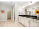Bright bathroom featuring double vanity with dark countertops and decorative sunflower accent at 1061 Verbena Ct, Tega Cay, SC 29708