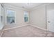 Neutral bedroom featuring carpet, crown molding, and two bright windows at 1061 Verbena Ct, Tega Cay, SC 29708