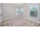 Neutral bedroom featuring carpet, crown molding, and two bright windows at 1061 Verbena Ct, Tega Cay, SC 29708