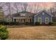 Charming single Gathering home featuring a cozy front porch and beautiful stone accents at dusk at 1061 Verbena Ct, Tega Cay, SC 29708