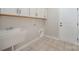 Functional laundry room with a sink, white cabinets, and a tile floor, offering practicality and convenience at 1061 Verbena Ct, Tega Cay, SC 29708