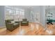 Bright living room with large windows and hardwood floors, featuring two armchairs and view into dining area at 1061 Verbena Ct, Tega Cay, SC 29708