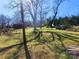 Large backyard with lush green grass, mature trees, and a wooden fence on a sunny day at 109 Oakland Ave, Chester, SC 29706