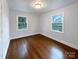 Bright bedroom featuring hardwood floors, two windows offering ample natural light, and fresh paint at 1429 Alexander Rd, Rock Hill, SC 29732