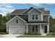 Charming two-story home featuring varied gray siding, a covered porch, and an attached garage at 162 Holsworthy Dr, Mooresville, NC 28115