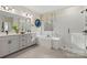 Bright bathroom with white cabinets, dual vanity, tub, and glass shower featuring black hardware and herringbone tile floors at 164 Holsworthy Dr, Mooresville, NC 28115