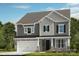 Charming two-story home showcasing a blend of stone accents and gray siding under a sunny sky at 164 Holsworthy Dr, Mooresville, NC 28115
