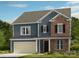 Charming two-story home featuring a blend of blue siding and brick accents, plus an attached two-car garage at 166 Holsworthy Dr, Mooresville, NC 28115