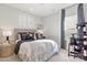 Stylishly designed bedroom with patterned bedding, bedside table, and a cat tree near the window at 173 Holsworthy Dr, Mooresville, NC 28115