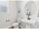 Clean powder room with a pedestal sink, round mirror, and a classic toilet at 173 Holsworthy Dr, Mooresville, NC 28115