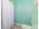 This is a partial view of a bathroom with a white shower curtain, light green walls, and a white toilet at 1847 Bertha Knight Rd, Lancaster, SC 29720