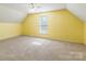 A carpeted bedroom is painted yellow and is equipped with a ceiling fan and a window at 1847 Bertha Knight Rd, Lancaster, SC 29720