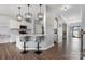 Open kitchen boasts white cabinetry, quartz countertops, pendant lighting, and two bar stools at 1875 Loggerhead Dr, Lancaster, SC 29720