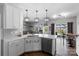 Open concept kitchen with stainless steel appliances, white cabinets, island and connected living area at 1875 Loggerhead Dr, Lancaster, SC 29720