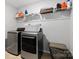 Well-organized laundry room with modern washer and dryer, shelving, and ample storage space at 1875 Loggerhead Dr, Lancaster, SC 29720