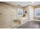 Spacious bathroom featuring a glass-enclosed shower, soaking tub, and neutral tones at 2305 Flintwood Ln, Charlotte, NC 28226