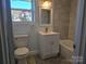 Modern bathroom with tub, updated vanity, stylish fixtures, and a window offering natural light at 245 College E Ave, Shelby, NC 28152