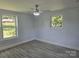 Bright bedroom featuring large windows and new flooring and a ceiling fan at 245 College E Ave, Shelby, NC 28152