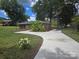 Wide concrete driveway leading to a brick home with mature trees and landscaping at 245 College E Ave, Shelby, NC 28152
