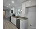 Bright kitchen with white cabinets, stainless steel appliances, granite countertops, and new gray vinyl floors at 245 College E Ave, Shelby, NC 28152