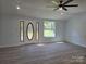 Spacious living room with gray vinyl floors, ceiling fan, and a large decorative glass front door at 245 College E Ave, Shelby, NC 28152
