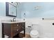 Bathroom featuring a dark wood vanity with marble countertop, toilet, and beadboard paneling at 262 Vermont Dr, Stanley, NC 28164